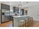 An open kitchen features gray cabinets, stainless steel appliances, a large island with seating, and stylish pendant lights at 3226 Helen Ave, Orlando, FL 32804