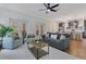 Open living area with a ceiling fan, grey sofa, accent chairs, and a kitchen bar with stainless steel appliances at 3226 Helen Ave, Orlando, FL 32804