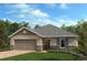 Charming single-story home featuring neutral toned exterior, attached two-car garage, manicured lawn, and beautiful landscaping at 3273 Sanctuary Dr, Clermont, FL 34714