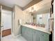 Bathroom featuring a dual sink vanity with gray-green cabinetry and a large, well-lit mirror at 404 Broadview Ave, Altamonte Springs, FL 32701