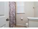 Bright bathroom featuring a walk-in shower with seashell-themed curtain, toilet, and window at 4952 Longmeadow Park St, Orlando, FL 32811