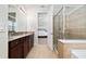 Bathroom with double sink vanity, granite countertop, glass shower, and access to the bedroom at 4952 Longmeadow Park St, Orlando, FL 32811