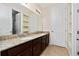 Bathroom with double sink vanity, granite counters, and tile flooring, with a view of the shower at 4952 Longmeadow Park St, Orlando, FL 32811