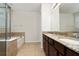 Bright and airy bathroom featuring double sinks, granite countertops, tiled floors, a bathtub, and glass-enclosed shower at 4952 Longmeadow Park St, Orlando, FL 32811