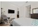 Cozy bedroom with a mounted television, rocker, and ensuite bathroom and closet access at 4952 Longmeadow Park St, Orlando, FL 32811