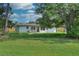Lovely home exterior highlighting a spacious backyard, a patio with seating, and a vibrant green lawn at 550 Eagle Dr, Daytona Beach, FL 32117