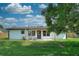 Charming home exterior featuring a spacious backyard, a patio, and manicured lawn, perfect for outdoor living at 550 Eagle Dr, Daytona Beach, FL 32117