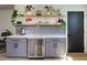 Stylish gray bar area with wine refrigerator, floating shelves, quartz countertop, and gray backsplash at 550 Eagle Dr, Daytona Beach, FL 32117