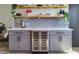 Built-in gray bar with quartz countertop, wine refrigerator, floating shelves, and gray backsplash at 550 Eagle Dr, Daytona Beach, FL 32117