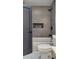 Bathroom with gray tiled walls, a shower, a bathtub, a toilet, a recessed shelf, and a gray bathroom door at 550 Eagle Dr, Daytona Beach, FL 32117