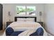 A modern bedroom features a plush bed, dark-trimmed doors, and lots of natural light from the window at 550 Eagle Dr, Daytona Beach, FL 32117