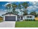 Charming one-story home featuring a gray garage door, manicured lawn, and neat landscaping at 550 Eagle Dr, Daytona Beach, FL 32117
