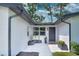 View of front door with a modern design, decorative cacti, and updated landscaping at 550 Eagle Dr, Daytona Beach, FL 32117