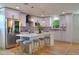 Bright eat-in kitchen featuring white cabinets, a gray backsplash, stainless steel appliances, and pendant lighting at 550 Eagle Dr, Daytona Beach, FL 32117