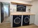Modern laundry room boasts black Samsung washing machines, wood counters, shiplap wall, and decor at 550 Eagle Dr, Daytona Beach, FL 32117