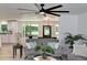 Open living room view to dining room and kitchen with gray sofas, plants, and unique ceiling fan at 550 Eagle Dr, Daytona Beach, FL 32117