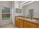 Bright bathroom features a dual sink vanity, large mirror and a window overlooking the backyard at 5559 Pats Pt, Winter Park, FL 32792