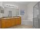 Bright bathroom featuring a dual sink vanity, soaking tub, and glass-enclosed shower at 5559 Pats Pt, Winter Park, FL 32792