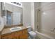 Cozy bathroom with tiled tub and shower, neutral walls, and wood vanity at 5559 Pats Pt, Winter Park, FL 32792