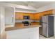 Functional kitchen featuring wood cabinets, stainless steel appliances, and an island bar at 5559 Pats Pt, Winter Park, FL 32792