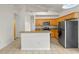 Open kitchen with stainless steel appliances, wood cabinets, and an island with bar seating at 5559 Pats Pt, Winter Park, FL 32792