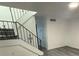 An interior staircase features stylish railings, hardwood floors, and new paint at 5930 Village Cir # Ge, Orlando, FL 32822