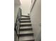 An interior staircase features stylish railings, hardwood floors, and new paint at 5930 Village Cir # Ge, Orlando, FL 32822