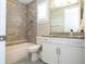 Well-lit bathroom featuring a shower-tub combo with sleek gray tile and modern white vanity with granite countertop at 682 Canopy Estates Dr, Winter Garden, FL 34787