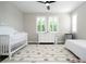 Bright bedroom featuring a crib, bed, and a stylish patterned rug with soft colors at 682 Canopy Estates Dr, Winter Garden, FL 34787