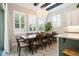 Dining area featuring a large wooden table, plantation shutters, and a chandelier, adjacent to the kitchen at 682 Canopy Estates Dr, Winter Garden, FL 34787