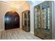 Elegant foyer showcasing a chandelier, display cabinets, wood-look tile flooring, and a grand double door at 682 Canopy Estates Dr, Winter Garden, FL 34787