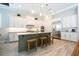 Bright kitchen with white cabinets, granite countertops, a central island with seating, and stainless steel appliances at 682 Canopy Estates Dr, Winter Garden, FL 34787