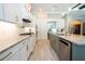 Well-lit, modern kitchen with stainless steel appliances, granite counters, and white cabinets with gold hardware at 682 Canopy Estates Dr, Winter Garden, FL 34787