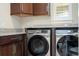 Close up view of a functional laundry room featuring modern washer and dryer and granite countertops at 682 Canopy Estates Dr, Winter Garden, FL 34787