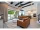 Bright, open-concept living room with coffered ceilings, stylish sofas, and sliding glass doors to the outdoor patio and pool area at 682 Canopy Estates Dr, Winter Garden, FL 34787
