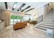 Bright living room with wood-look tile floors, coffered ceiling, comfortable leather sofas and sliding glass doors to the patio at 682 Canopy Estates Dr, Winter Garden, FL 34787