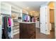 Large walk-in closet featuring custom shelving, a central island and wooden floors at 682 Canopy Estates Dr, Winter Garden, FL 34787