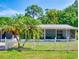 Quaint one-story home with screened porch, framed by palm trees and a white picket fence at 720 Meadow St, Sanford, FL 32773
