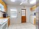 Bright kitchen featuring white appliances, tile floors, and a window overlooking the backyard at 720 Meadow St, Sanford, FL 32773