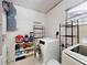 A laundry room with a modern washer and dryer, storage shelves, and a window at 720 Meadow St, Sanford, FL 32773