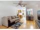Bright living room with television, hardwood floors, and a glimpse of the kitchen at 720 Meadow St, Sanford, FL 32773