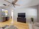 Bright living room with television, hardwood floors, and a glimpse of the kitchen at 720 Meadow St, Sanford, FL 32773