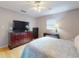 Main bedroom with hardwood floors, fan, and a large TV at 720 Meadow St, Sanford, FL 32773