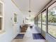 Large, bright, screened-in porch featuring wicker seating, ceiling fan, and multiple access doors at 720 Meadow St, Sanford, FL 32773