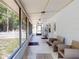 Inviting screened-in porch with wicker seating and view of the fenced yard at 720 Meadow St, Sanford, FL 32773
