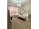 Comfortable bedroom featuring a chandelier, pink accents, and a cozy reading corner near a window at 813 Greybull Run, Lake Mary, FL 32746