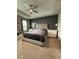 Bedroom with a large tufted bed, tray ceilings, gray accent wall, and two windows at 813 Greybull Run, Lake Mary, FL 32746