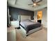Bedroom with large tufted headboard bed, tray ceilings, and accent wall at 813 Greybull Run, Lake Mary, FL 32746