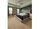 Cozy bedroom with a tufted headboard, large windows, tray ceiling, and stylish accent wall at 813 Greybull Run, Lake Mary, FL 32746
