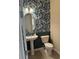 Charming powder room with pedestal sink, oval mirror, and stylish blue leafy wallpaper at 813 Greybull Run, Lake Mary, FL 32746